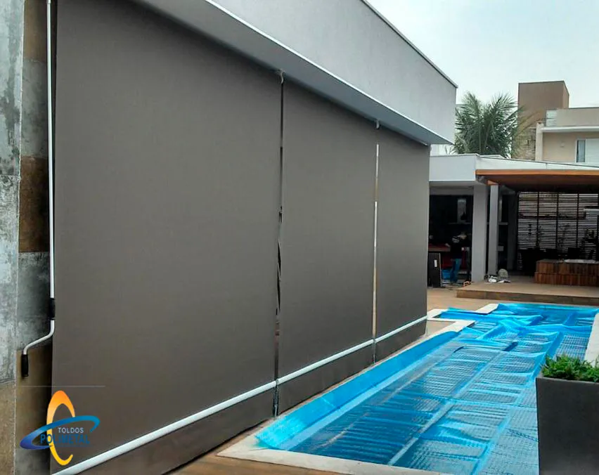 Toldo cortina blecaute em lona escura fechando área de piscina