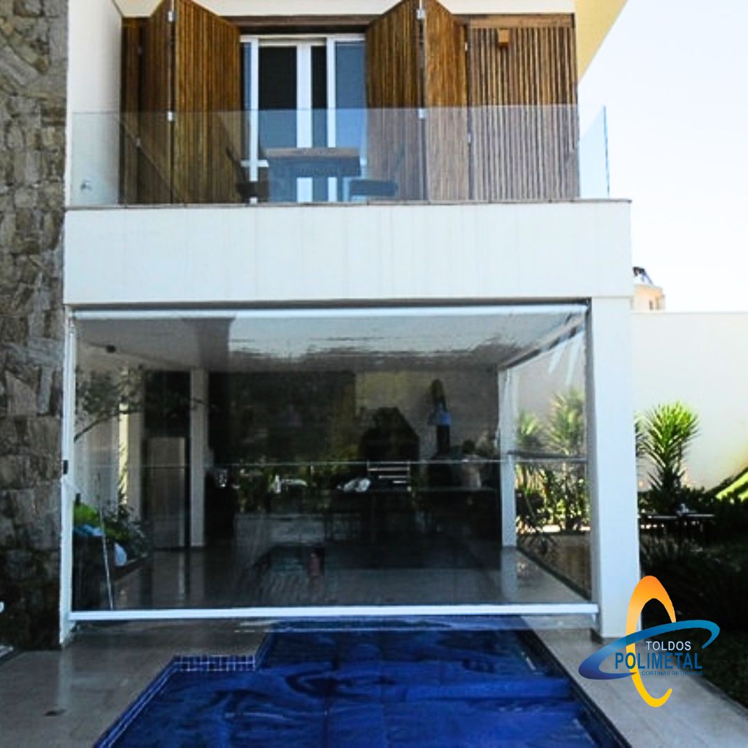 Toldo cortina transparente fechando área de piscina em residência