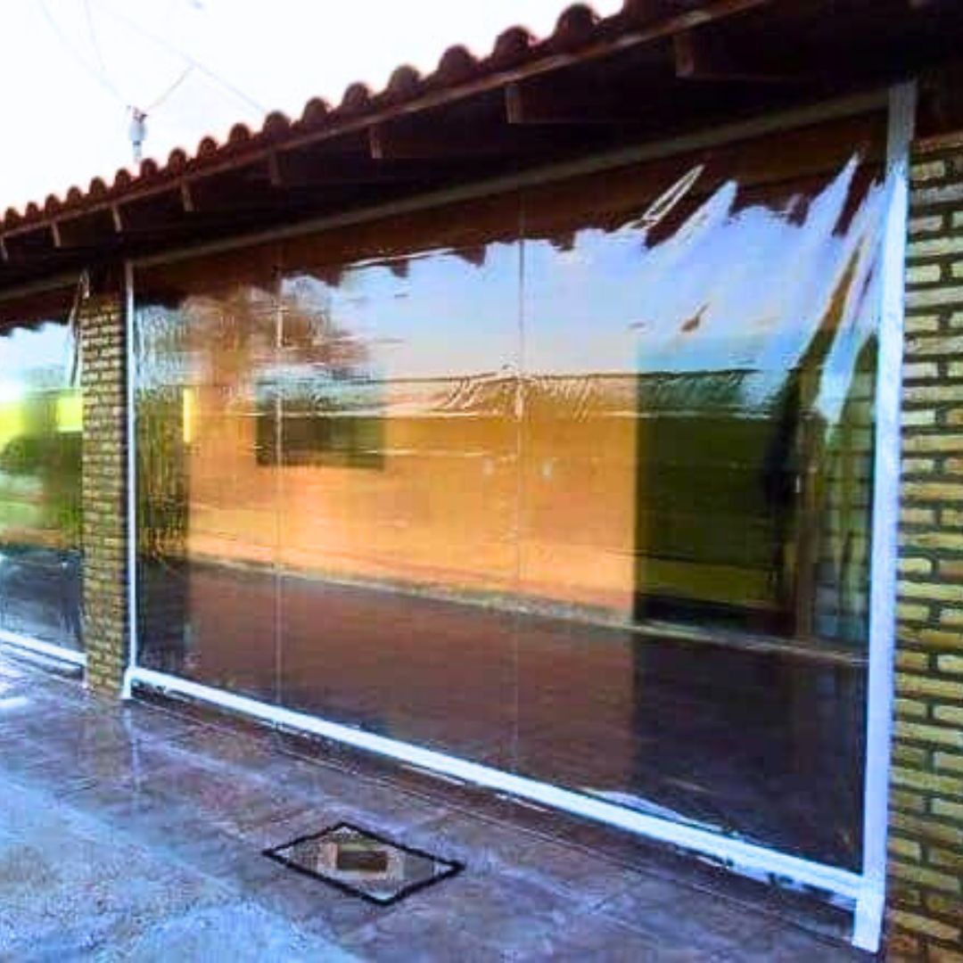 Toldo cortina transparente fechando fachada em dia de chuva