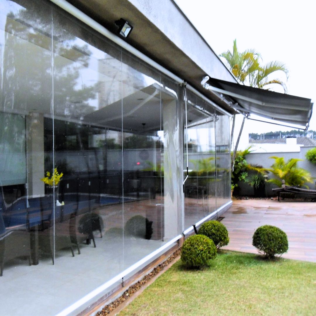 Toldo cortina transparente protegendo área de piscina